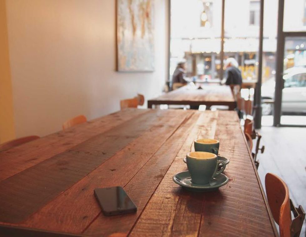 A long shared worktable in a bright studio space
