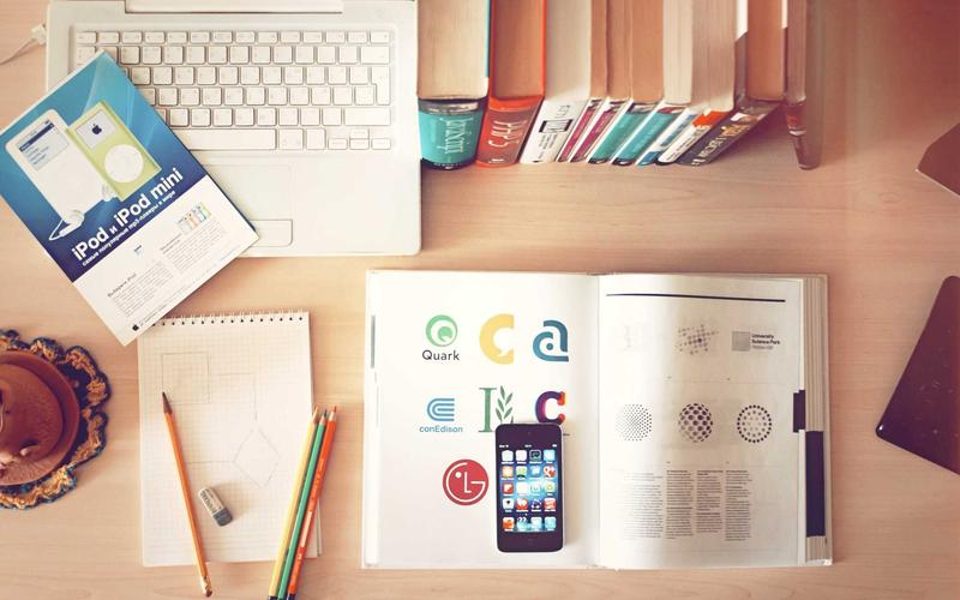 A desk with books and colourful printed material