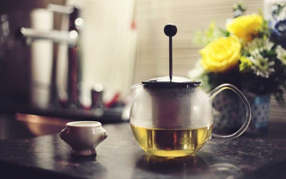 A pot of tea and flowers on a table